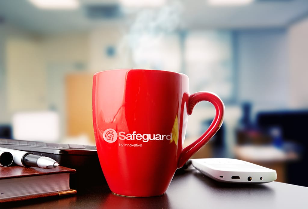A Safeguard-branded mug sitting on a desk.