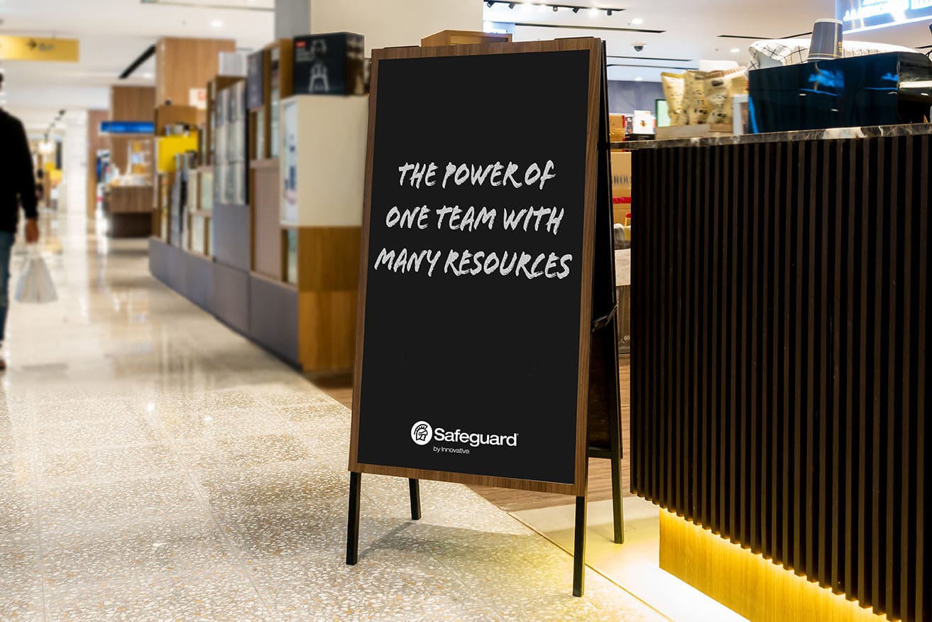 A sign in a store with the Safeguard slogan: The Power of One Team with Many Resources.