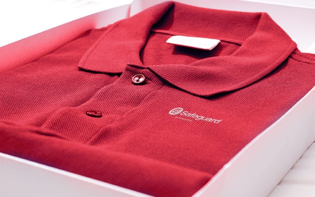 Safeguard-branded polo shirt folded inside a box.