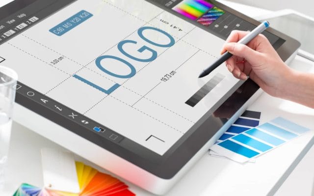 Designer working on an electronic screen to design a logo with a pen.