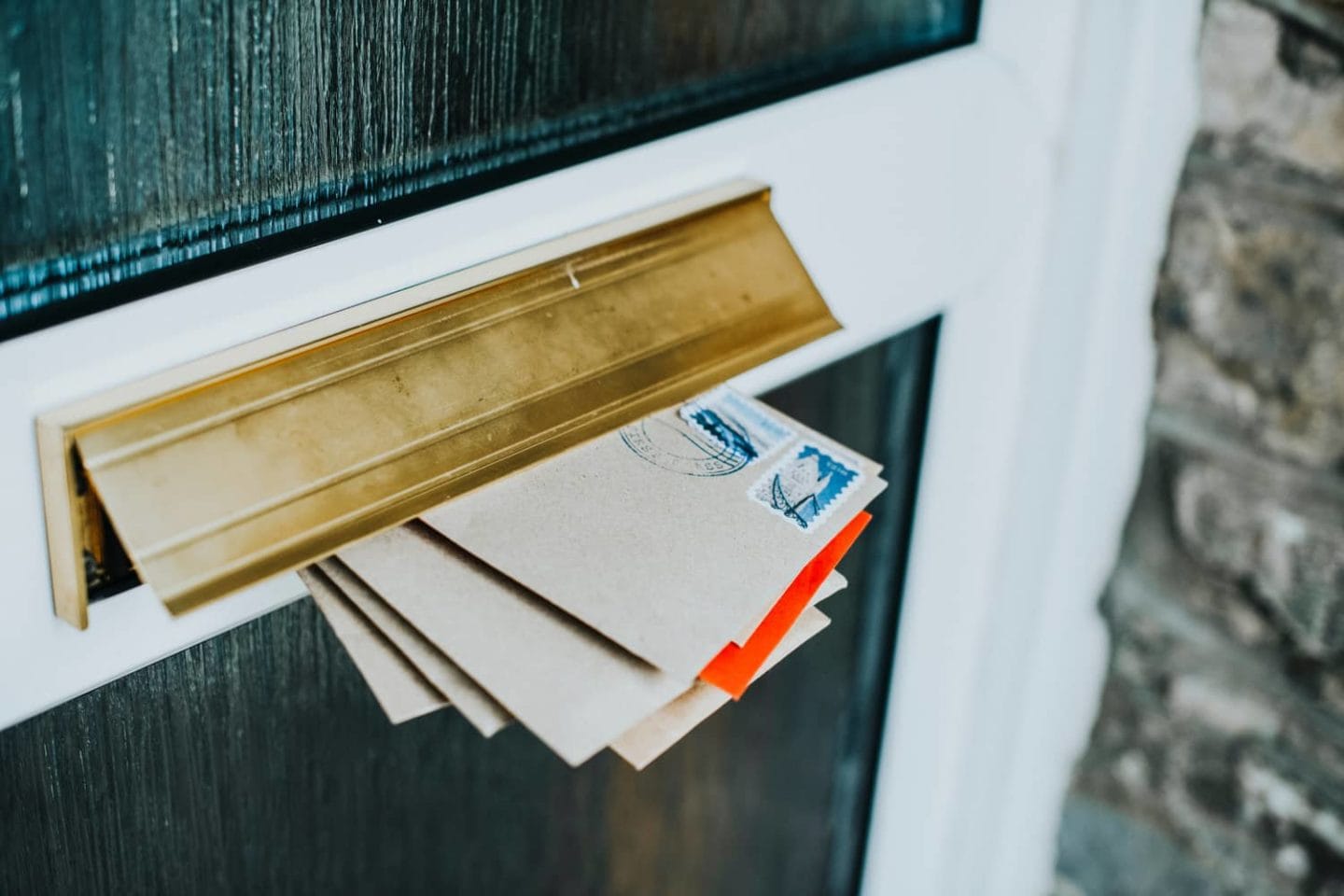 Letters stuffed inside a mail slot on a door.