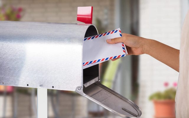 Hand mailing letters in mailbox