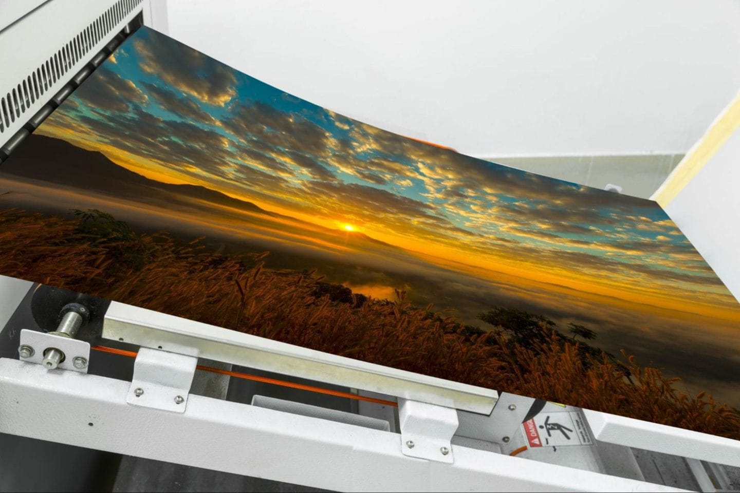 A large, digitally printed image of a horizon at sunset.