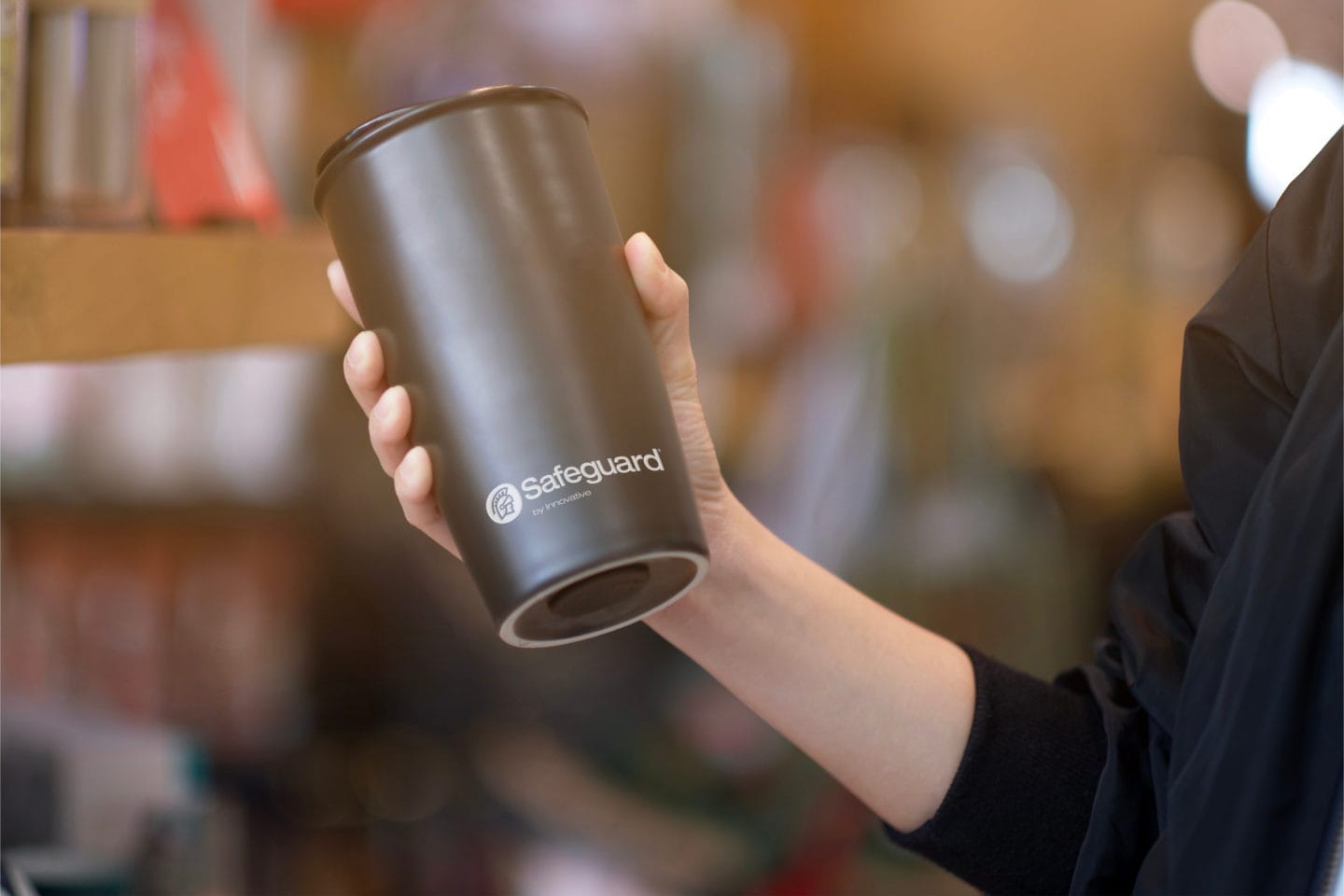 A hand holding a Safeguard-branded thermos.
