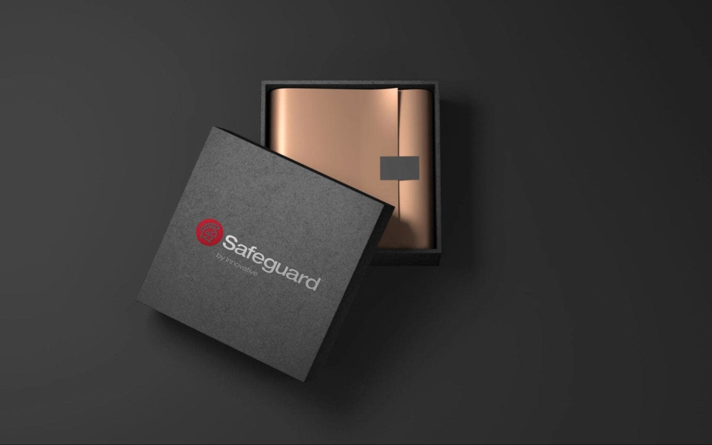 A dark grey gift box half open with a rose gold wrapped gift on the inside.
