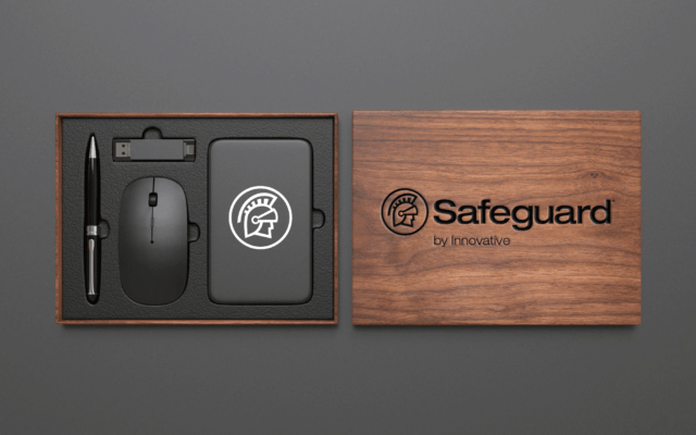 A wooden box with the Safeguard by Innovative logo on it holds a computer mouse, USB, pen, and power bank.